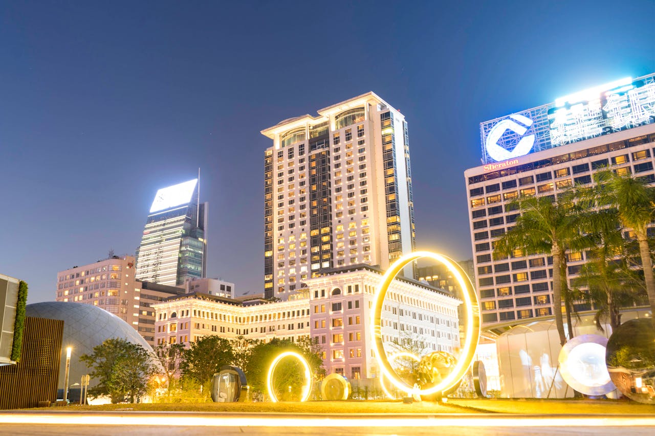 Stunning cityscape at night featuring modern architecture and illuminated light rings in an urban setting.